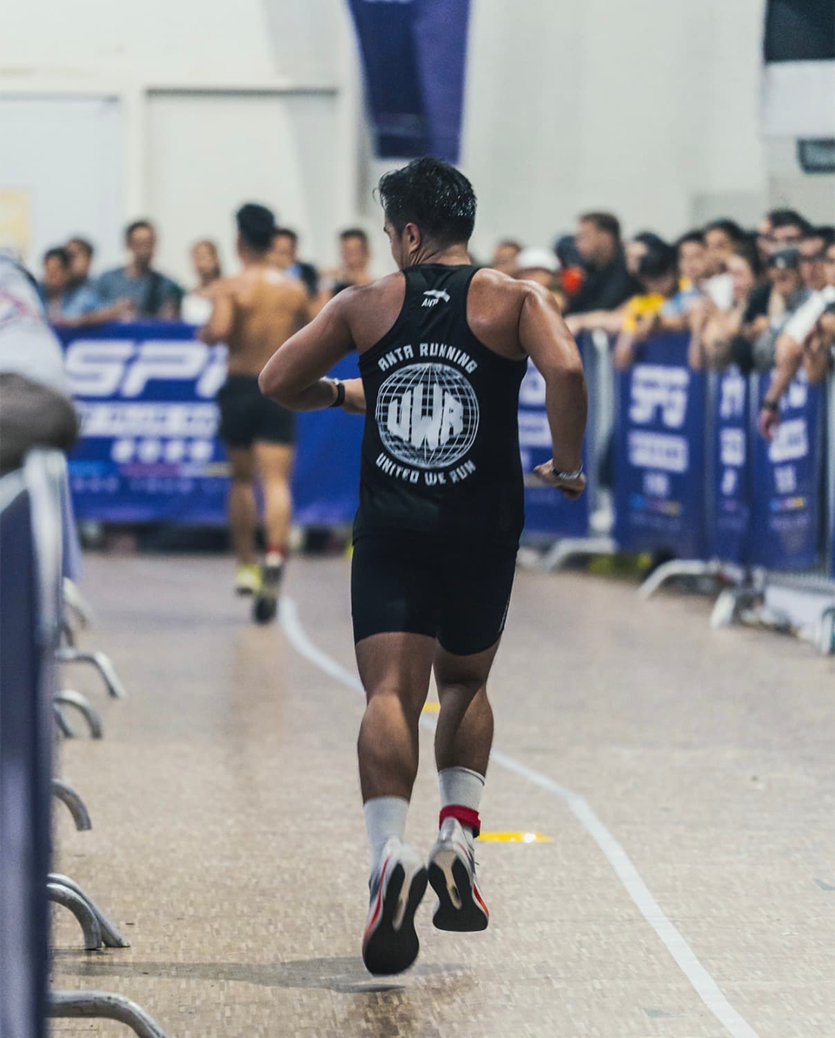 Coach Vans Catindoy racing in an ANTA Running United We Run singlet